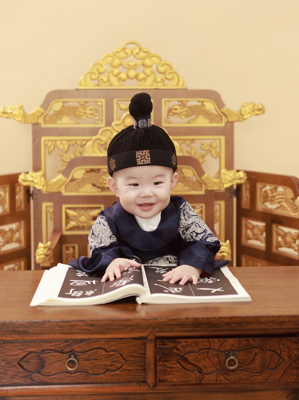 한복을 입고 책상 앞에서 미소 짓는 태율의 돌 사진